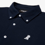Close-up of the collar and upper part of a navy blue button-down shirt, showing the buttons and embroidered logo.