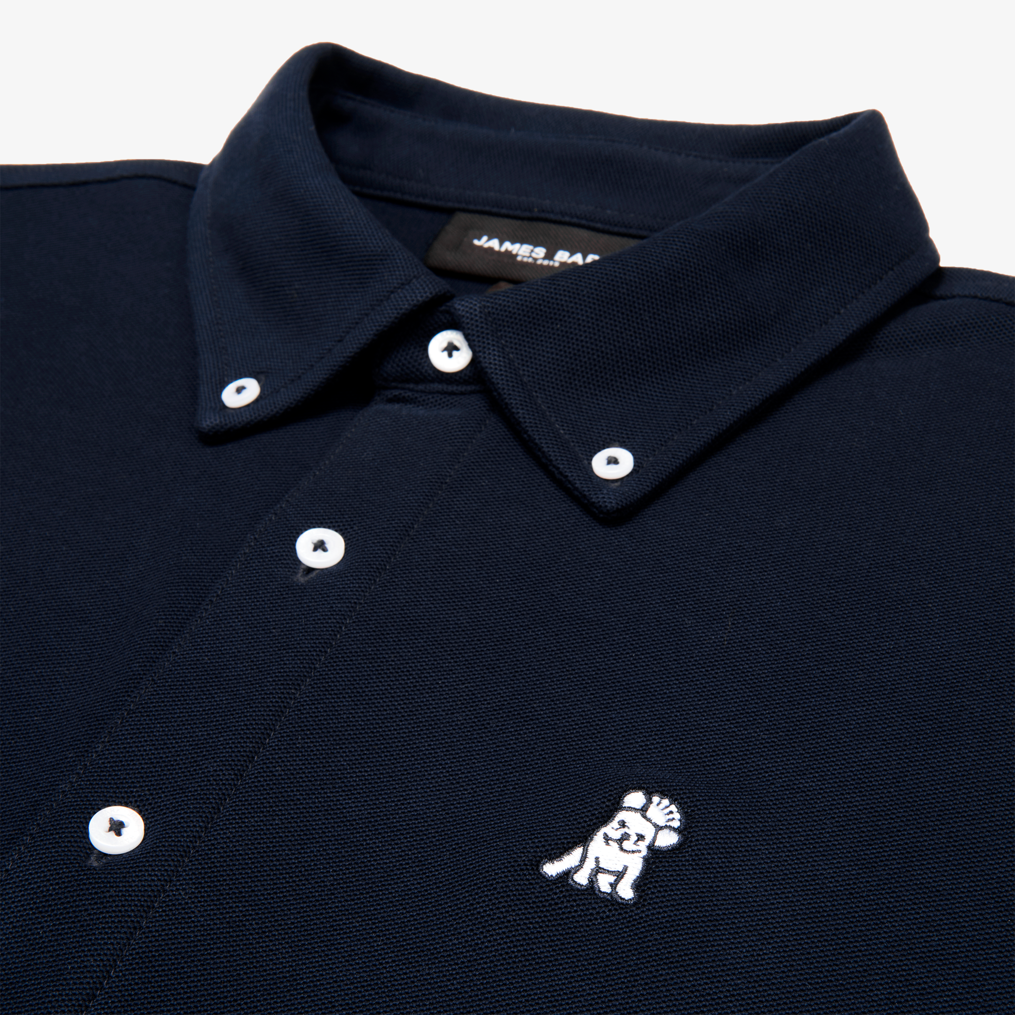 Close-up of the collar and upper part of a navy blue button-down shirt, showing the buttons and embroidered logo.