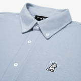 Close-up of the collar and upper part of a light blue button-down shirt, showing the buttons and embroidered logo.