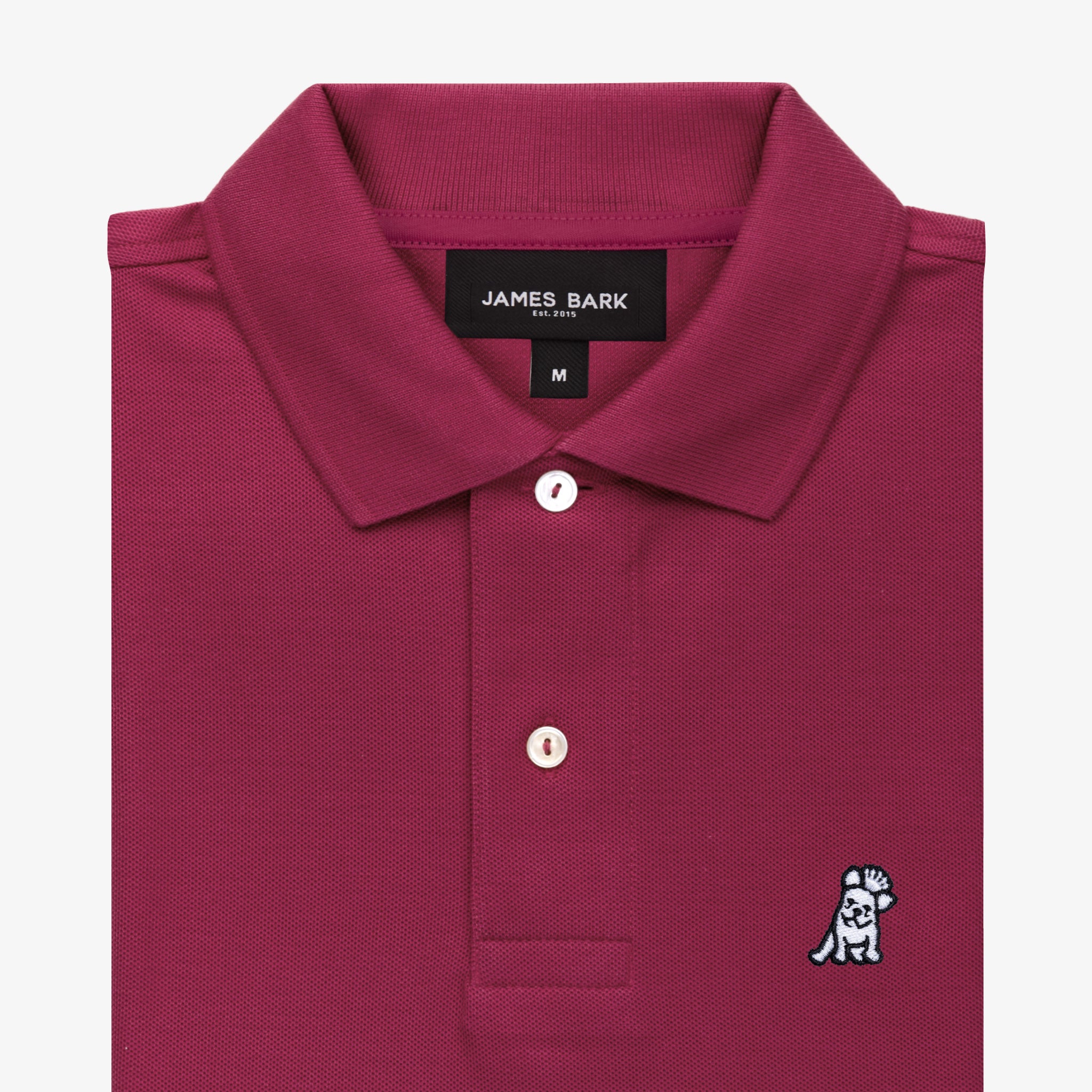 Close-up of the collar area of the burgundy polo shirt, showing the brand label and a small embroidered logo.