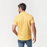 Rear view of the man wearing the yellow polo shirt, displaying the back fit and style.
