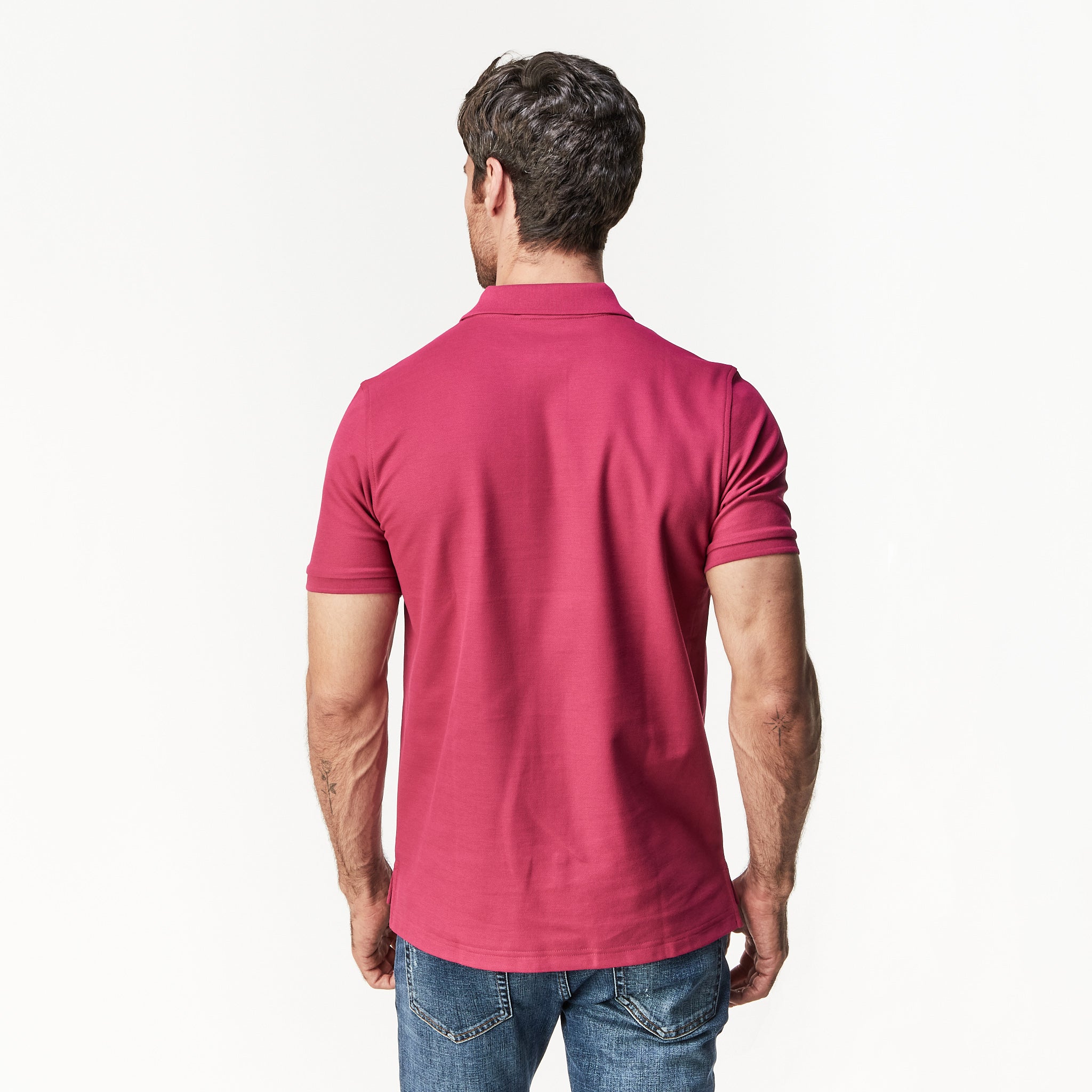 Rear view of the man wearing the burgundy polo shirt, displaying the back fit and style.
