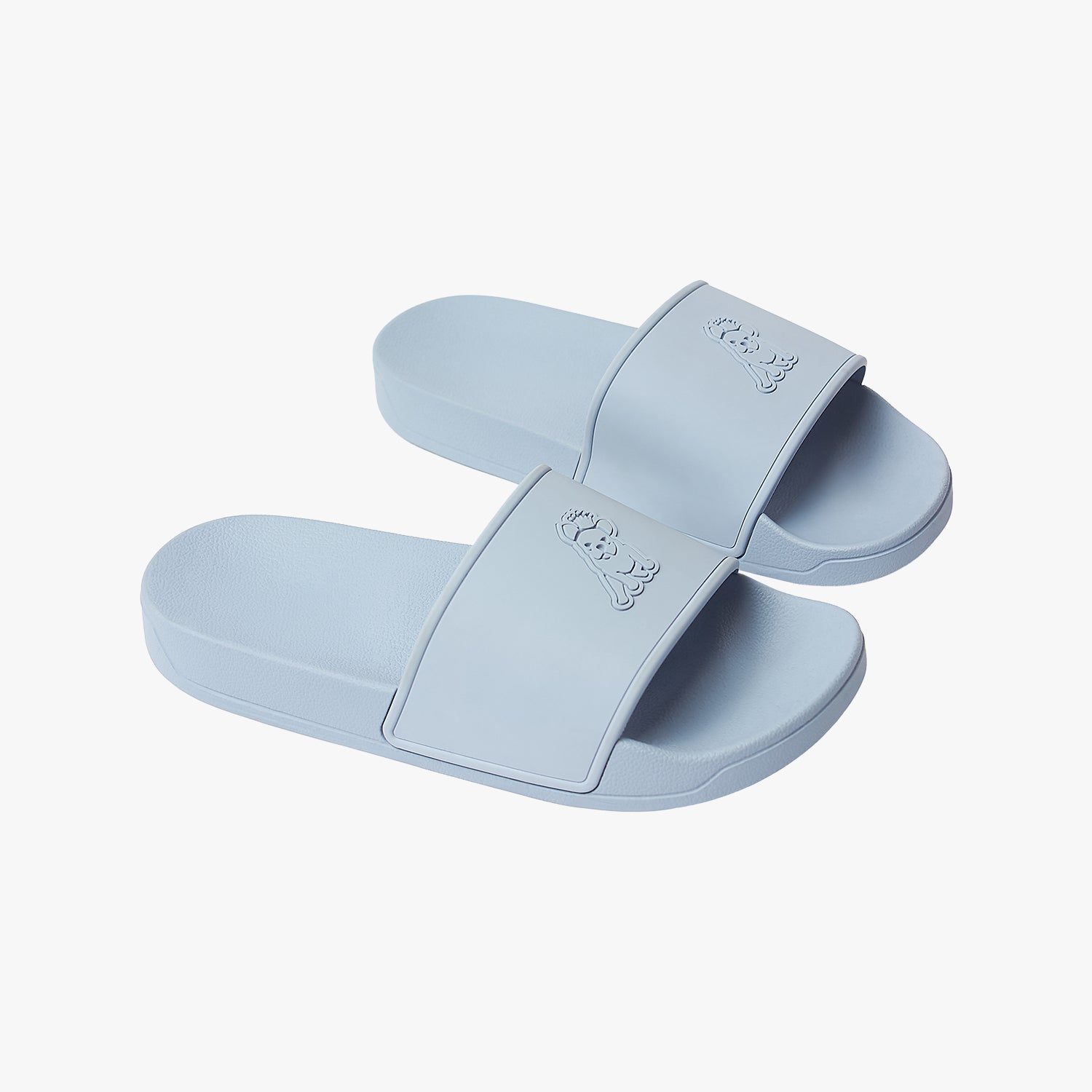 Diagonal view of the pair of sky blue slides, clearly displaying the symmetrical dog logo design across both straps