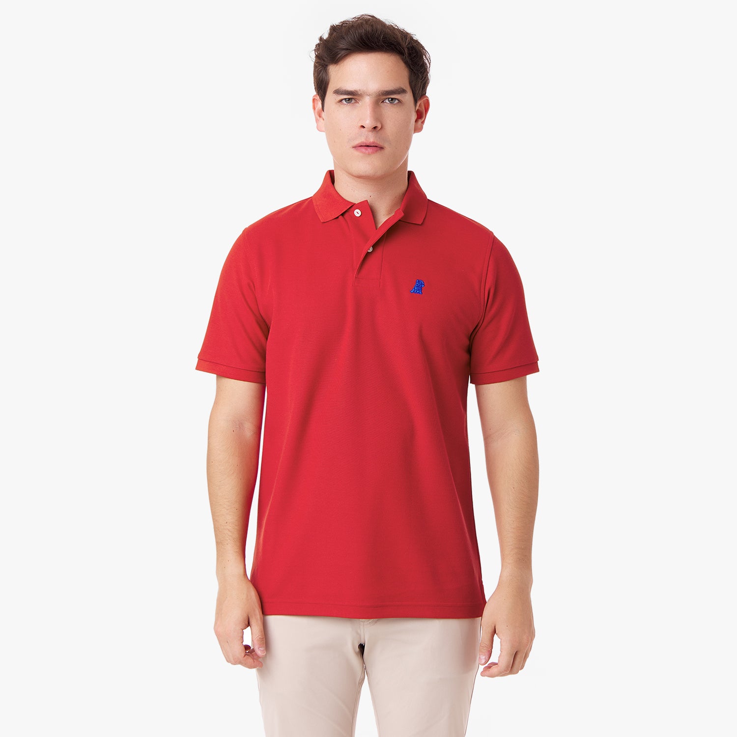 Male model wearing a red polo shirt with a blue embroidered dog logo and tan pants, standing front view