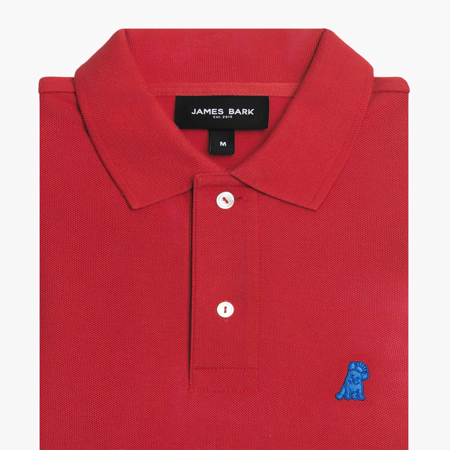 Folded red polo shirt, showing collar, buttons, brand tag, and blue embroidered dog logo on the chest