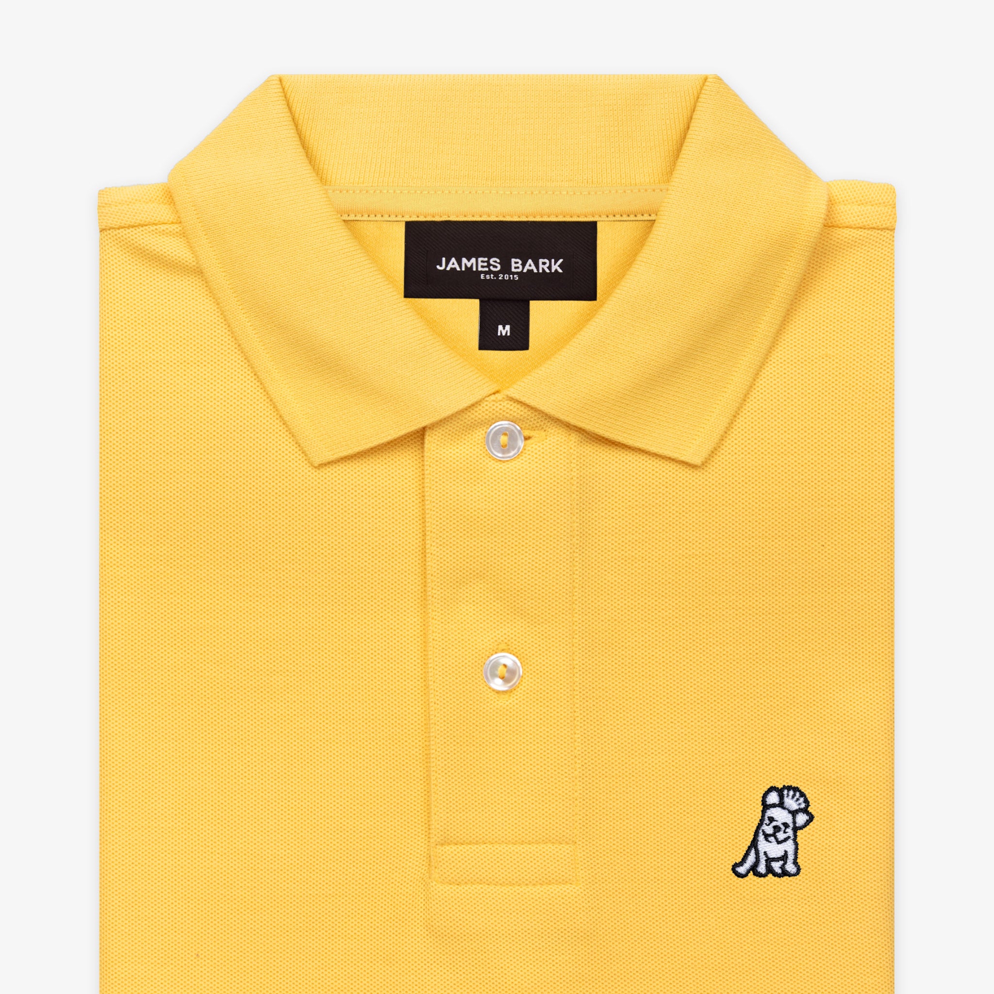 Close-up of the collar area of the yellow polo shirt, featuring the brand label and a small embroidered logo.