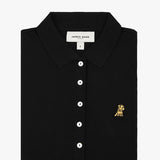 Flat-lay view of the black polo shirt with buttons and a gold logo on the chest.