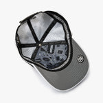 An overhead view of a gray snapback cap with a black brim, black mesh back panels, and a black adjustable strap. 