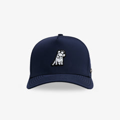 A navy blue baseball cap featuring a small embroidered dog patch on the front