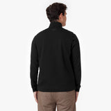  A back view of the model wearing the black jacket, showing its plain design with no visible branding or embellishments.