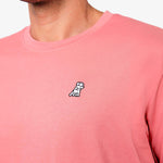 Side view close-up of the collar and chest of the pink t-shirt: A detailed side profile showing the crew neck collar and the small embroidered dog logo on the left chest.