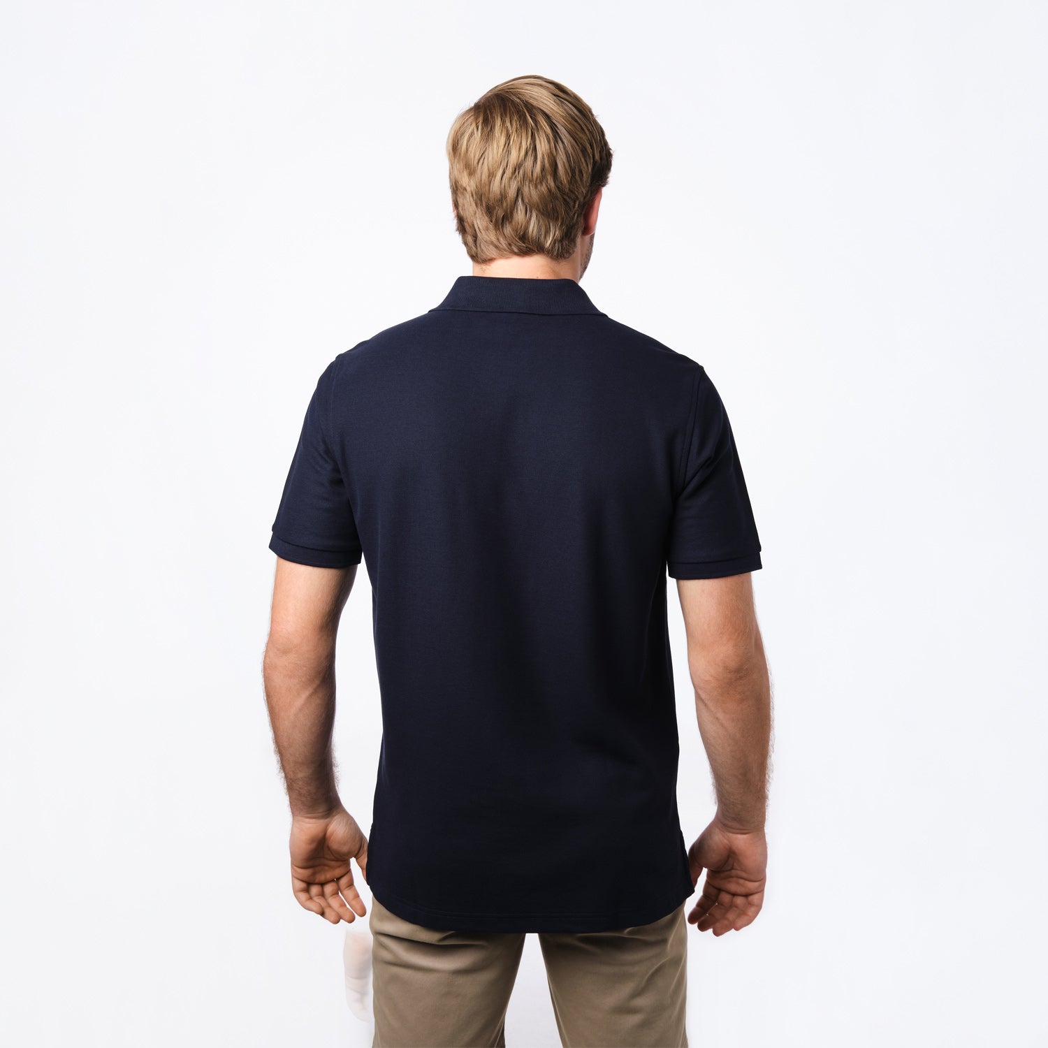 Rear view of the man wearing the navy blue polo shirt.