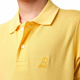 Close-up of the chest area of the yellow polo shirt, featuring the small gold embroidered logo.