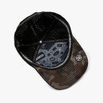 A black and brown camouflage baseball cap shown from an overhead angle, featuring a black mesh back, a patterned visor, and a circular patch on the side.