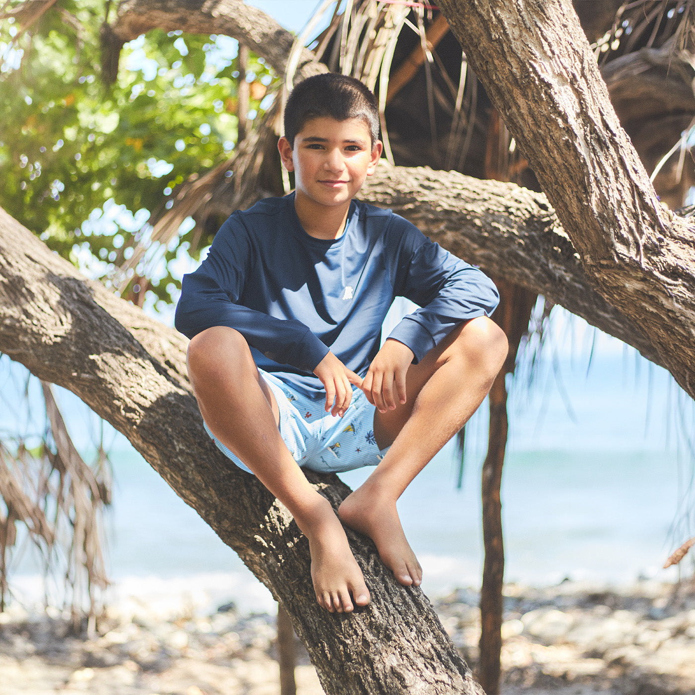 Child sitting in a tree with a natural background