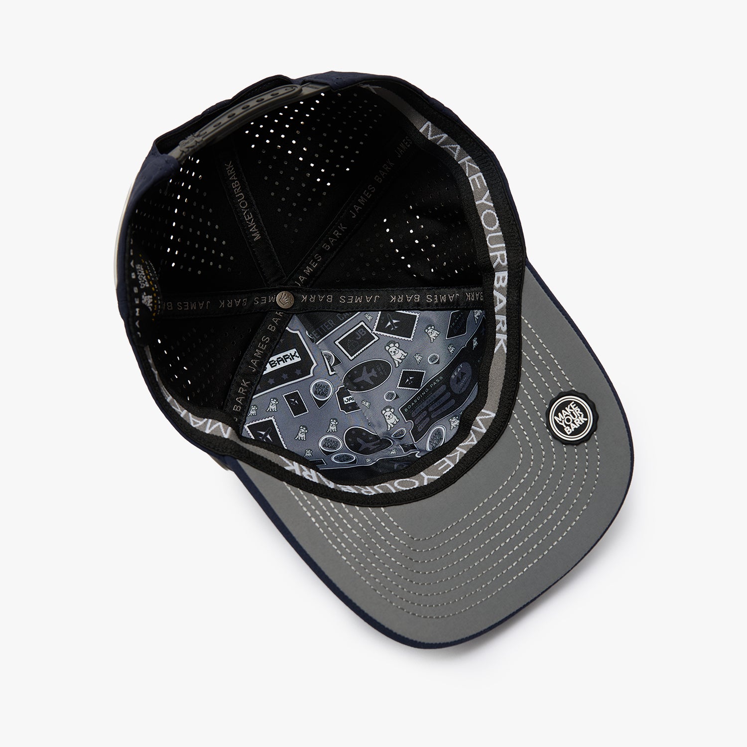 A black and gray baseball cap shown from an overhead angle, featuring a black mesh back, a gray visor with a subtle geometric pattern, and a circular patch on the side.