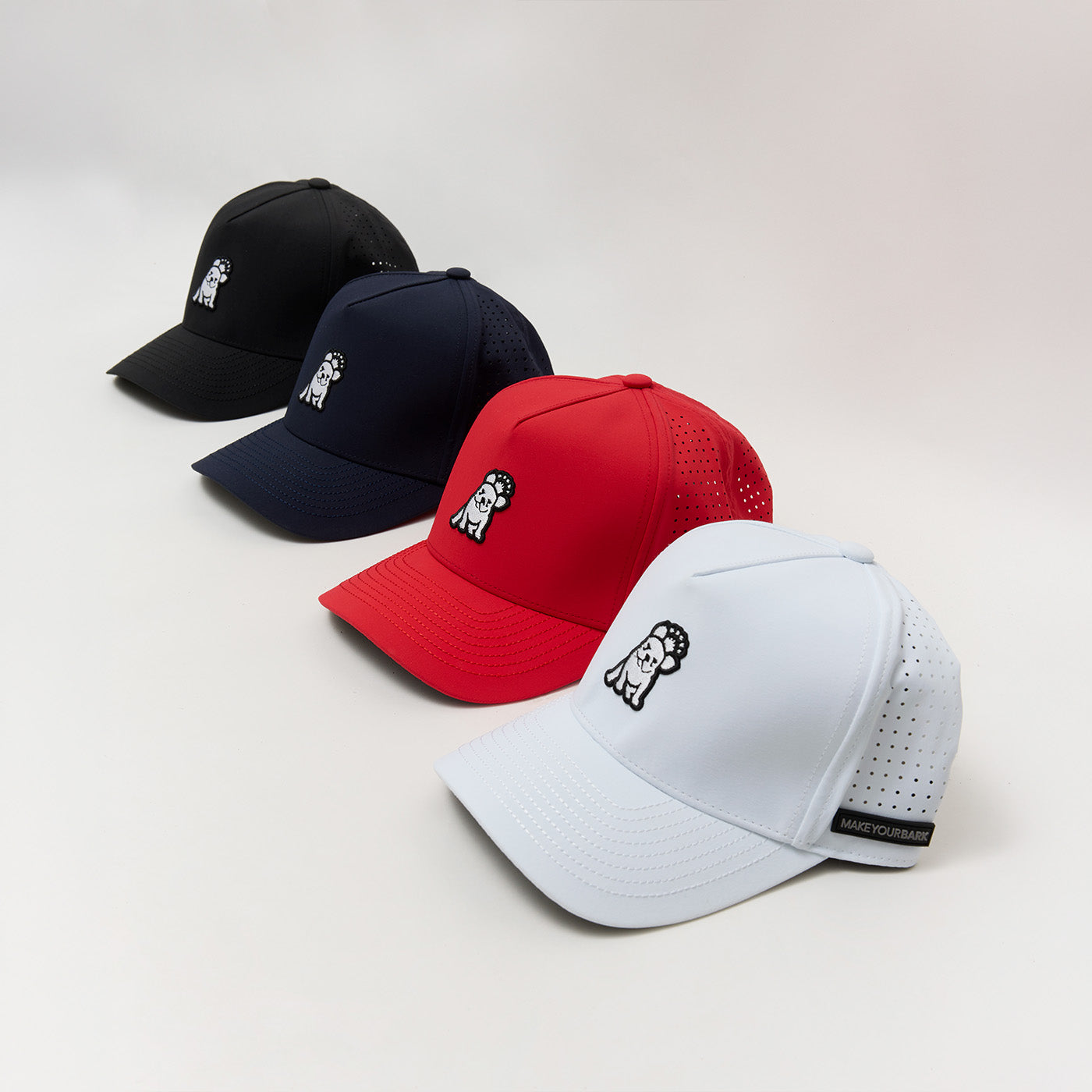 Lineup of James Bark baseball caps in black, navy, red, and white, featuring a Frenchie logo patch and perforated side panels.