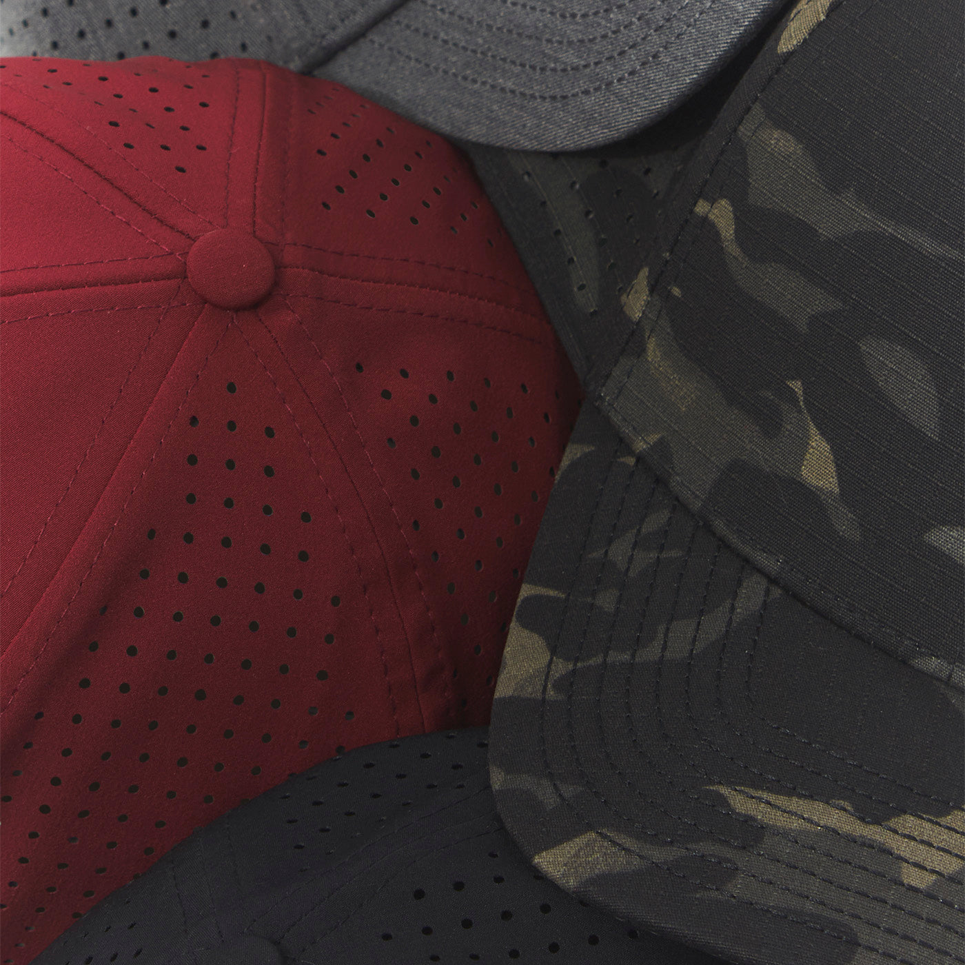 Close-up of three baseball caps with different designs and colors.