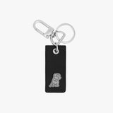 Stylish keychain featuring a rectangular black leather tag with a silver embossed dog logo at the bottom. The tag is paired with a polished silver keyring and a clasp hook, offering a modern and functional accessory.