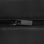 A zoomed-in view of the side panel of the toiletry bag, focusing on the embossed dog logo for a branded touch.