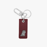 Elegant keychain featuring a rectangular burgundy leather tag with a silver embossed dog logo at the bottom. The tag is attached to a polished silver keyring and a clasp hook for added utility.