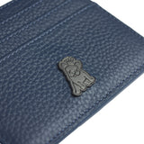 Close-up view of a blue textured leather cardholder featuring a small metallic emblem of a dog with a crown, adding a unique branding element to the accessory.