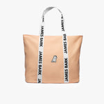 Peach-colored tote bag with a white dog logo embroidered on the front. The bag has white handles with 'James Bark' printed in black along the straps.