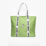 Green tote bag with a white dog logo embroidered on the front. The bag has white handles with 'James Bark' printed in black along the straps.