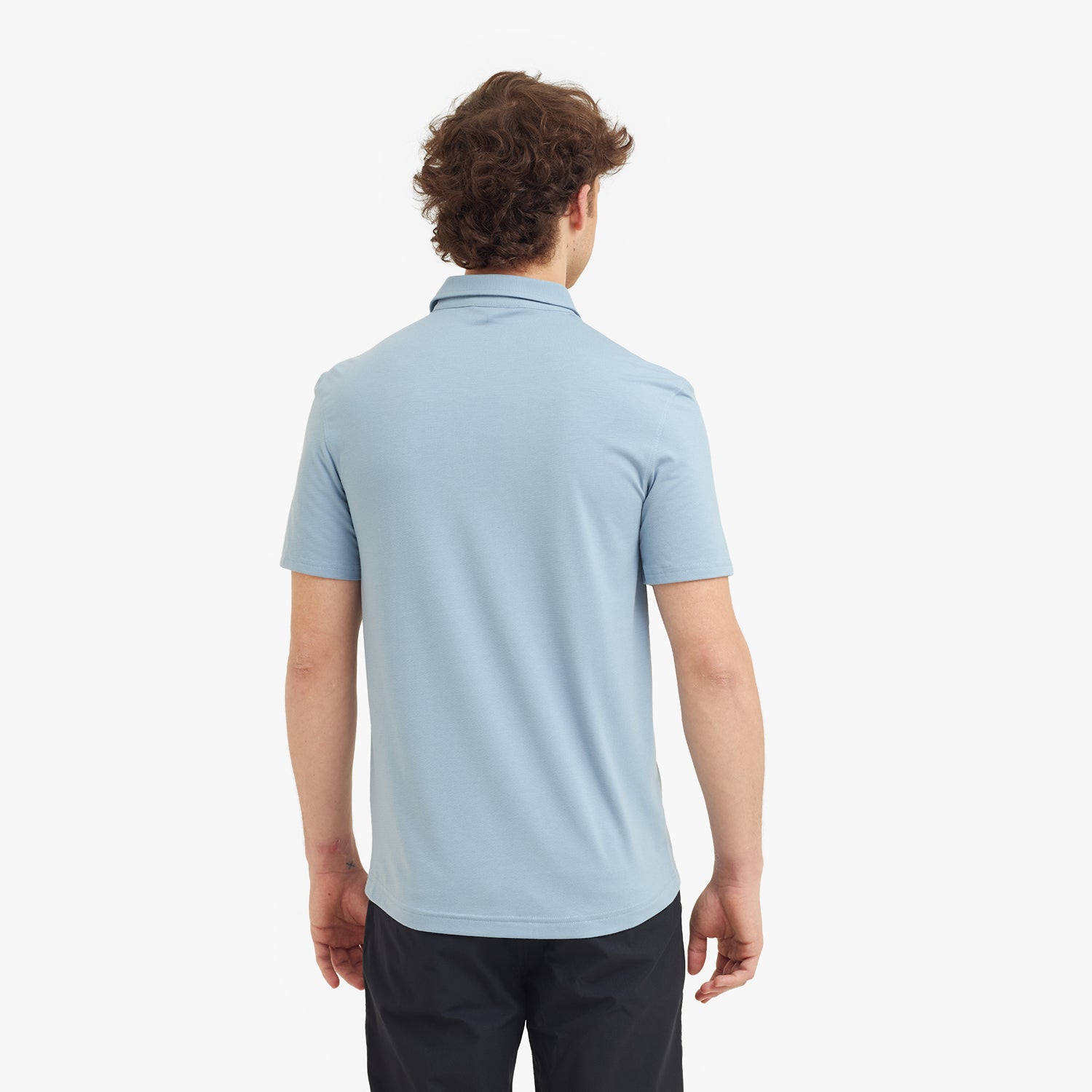 Person wearing a light blue polo shirt on a white background