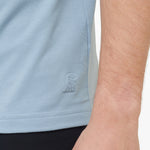 Light blue sleeveless shirt with a brand logo on a person wearing it.