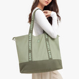 Person holding a green tote bag with 'Bark James Bark' branding.