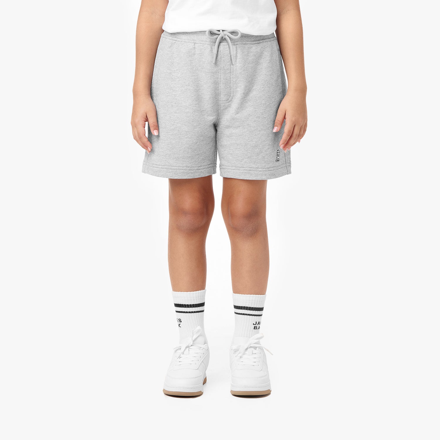 Front view of a child wearing gray shorts with a drawstring waist, paired with white sneakers and striped socks featuring the 'James Bark' logo.