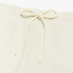 Close-up of the drawstring waistband on the cream-colored shorts, emphasizing the adjustable fit