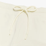 Close-up of the drawstring waistband on the cream-colored shorts, emphasizing the adjustable fit