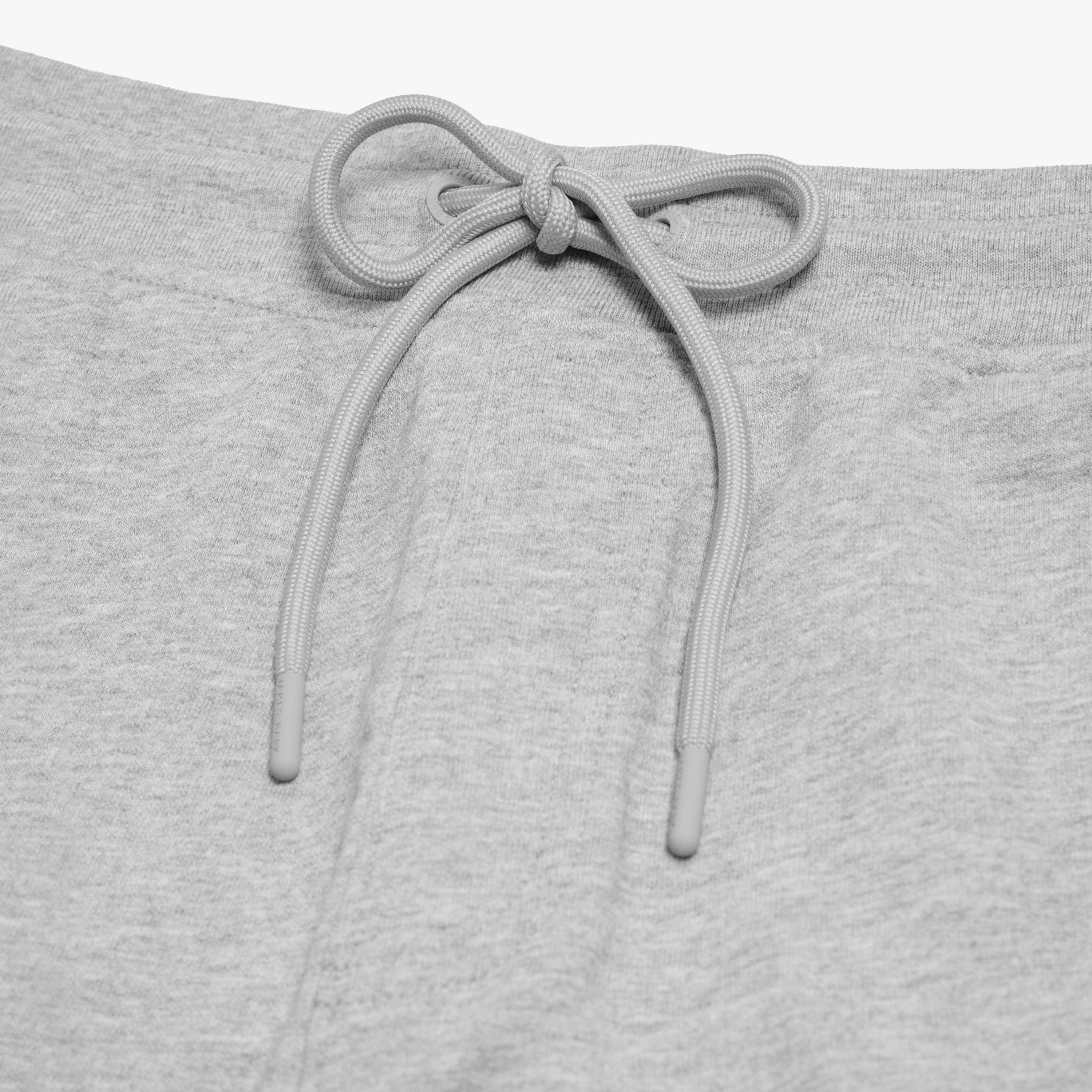 Close-up of the drawstring waistband on the gray shorts, focusing on the adjustable fit and soft fabric