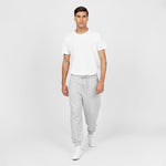 Full-body image of a man wearing a plain white T-shirt paired with light gray jogger-style sweatpants featuring a drawstring waist and cuffed ankles. The man is also wearing white sneakers and standing in a relaxed pose against a plain white background." Let me know if you'd like any edits