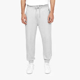 Front view of a person wearing light gray jogger-style sweatpants with a drawstring waist, paired with white sneakers. The person is also wearing a white T-shirt, and the background is plain white." Let me know if you'd like to make any changes