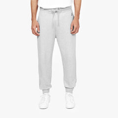 Front view of a person wearing light gray jogger-style sweatpants with a drawstring waist, paired with white sneakers. The person is also wearing a white T-shirt, and the background is plain white." Let me know if you'd like to make any changes