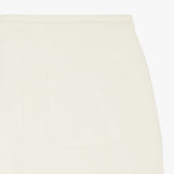 Close-up of the back pocket on the cream-colored jogger pants, highlighting the subtle details