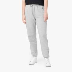 This image shows a pair of light grey sweatpants paired with a simple black t-shirt and white sneakers. The pants feature an embroidered logo on the upper side, adding a touch of detail to a clean, sporty look. The design is comfortable and casual, perfect for relaxed days or activewear.