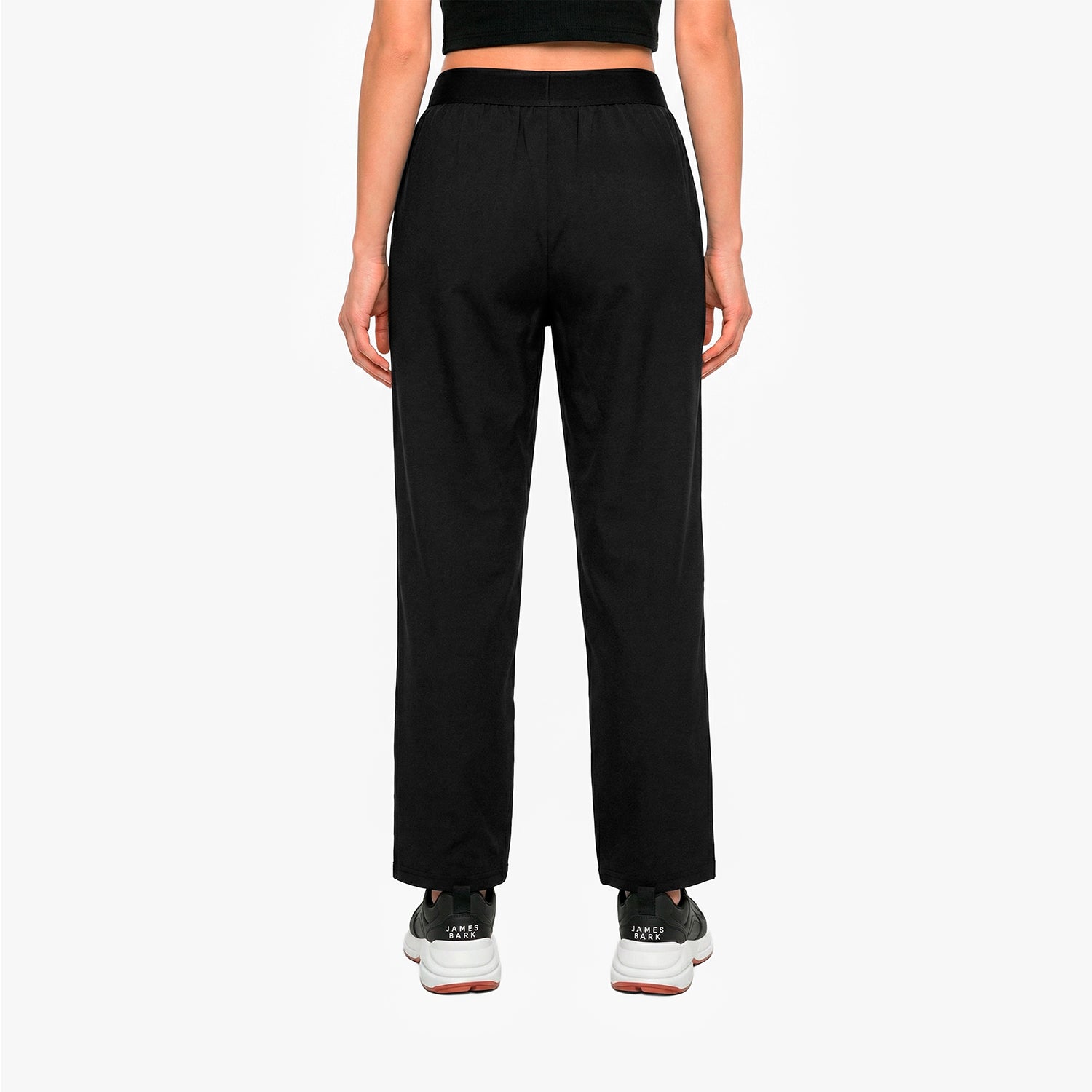 Person wearing black high-waisted pants on a white background