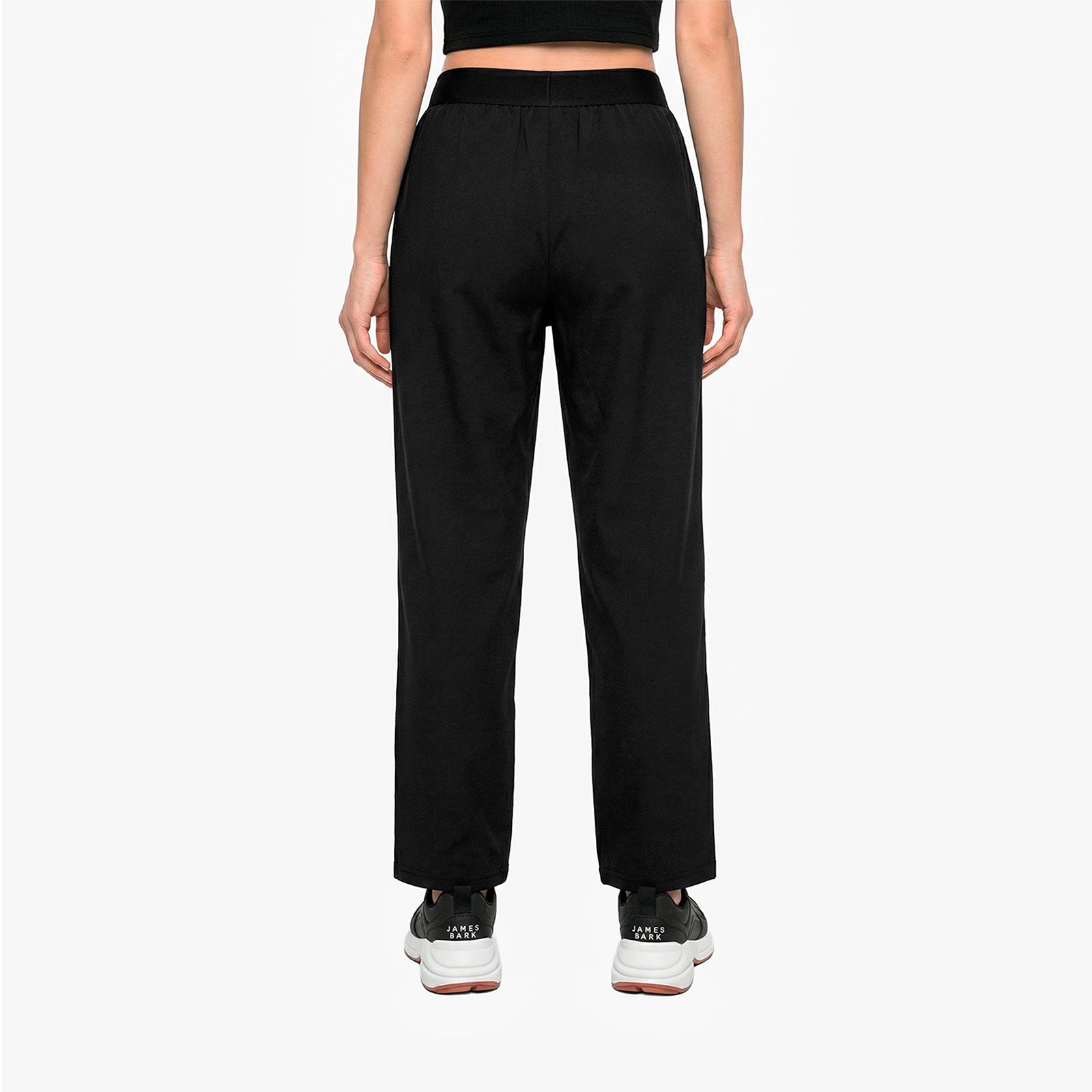 Person wearing black high-waisted pants on a white background