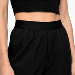 Black athletic pants with 'JAMES BARK' waistband on a neutral background