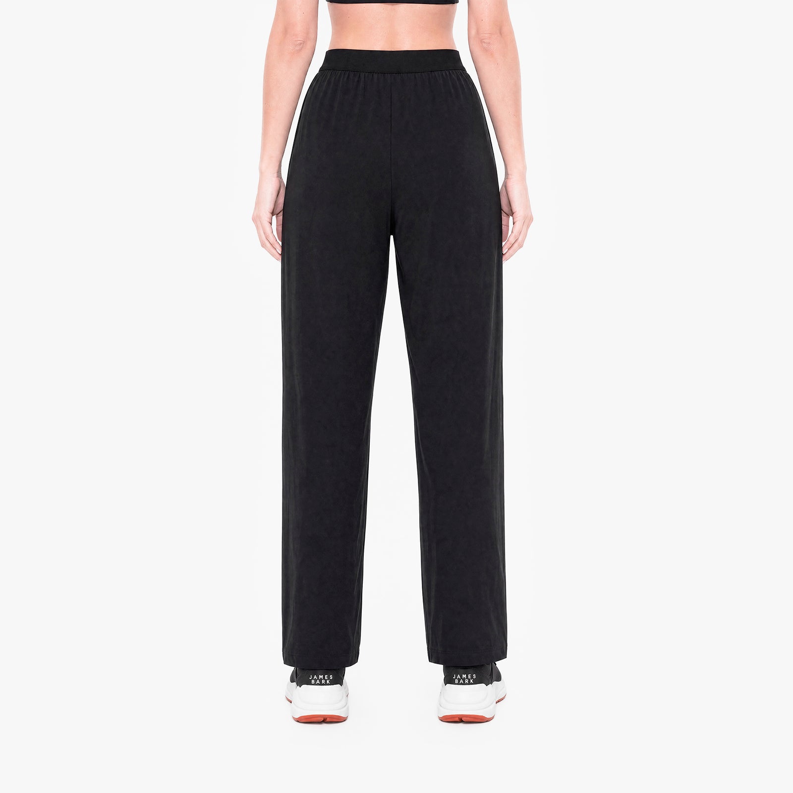 Person wearing black high-waisted pants on a white background