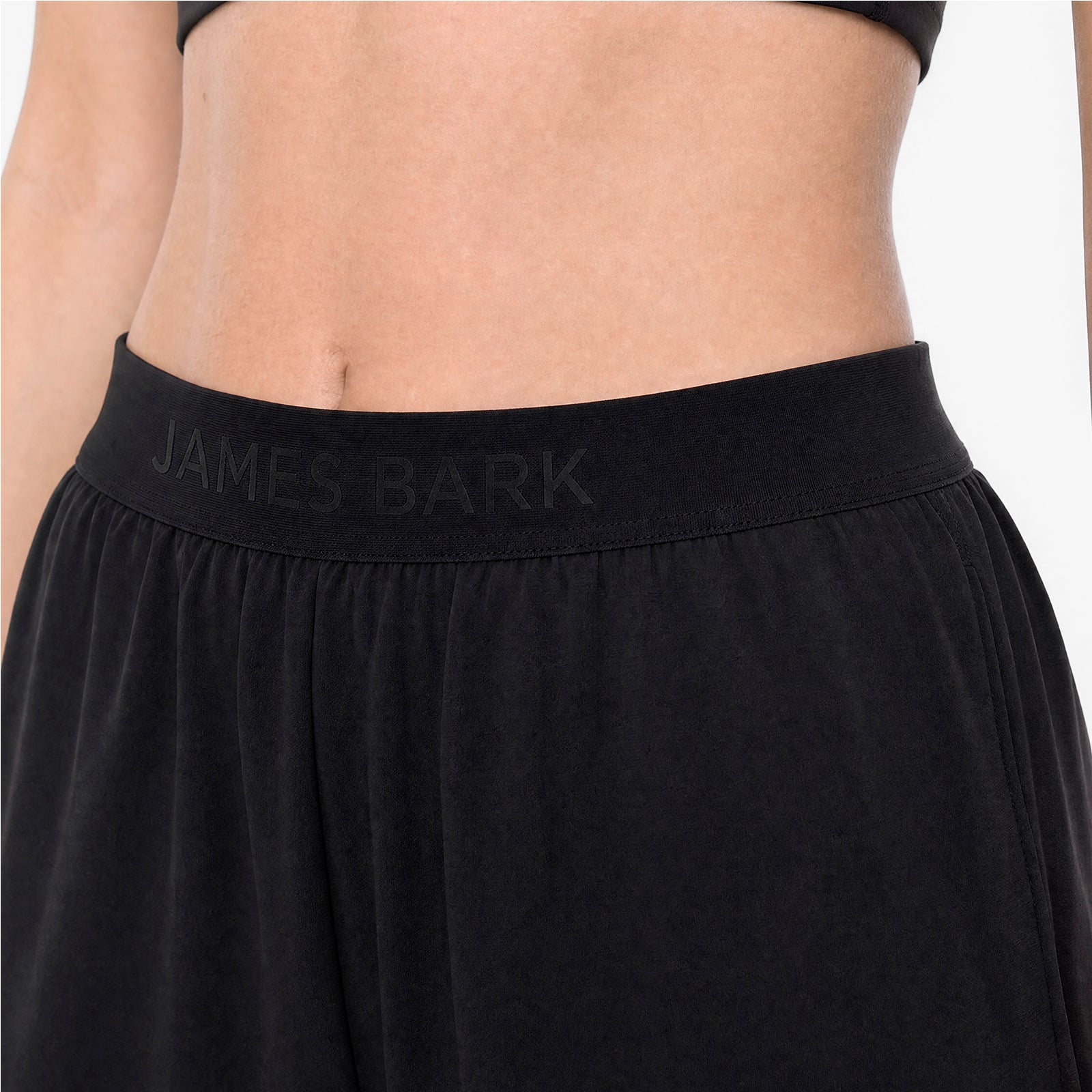 Black athletic pants with 'James Bark' branding on a neutral background