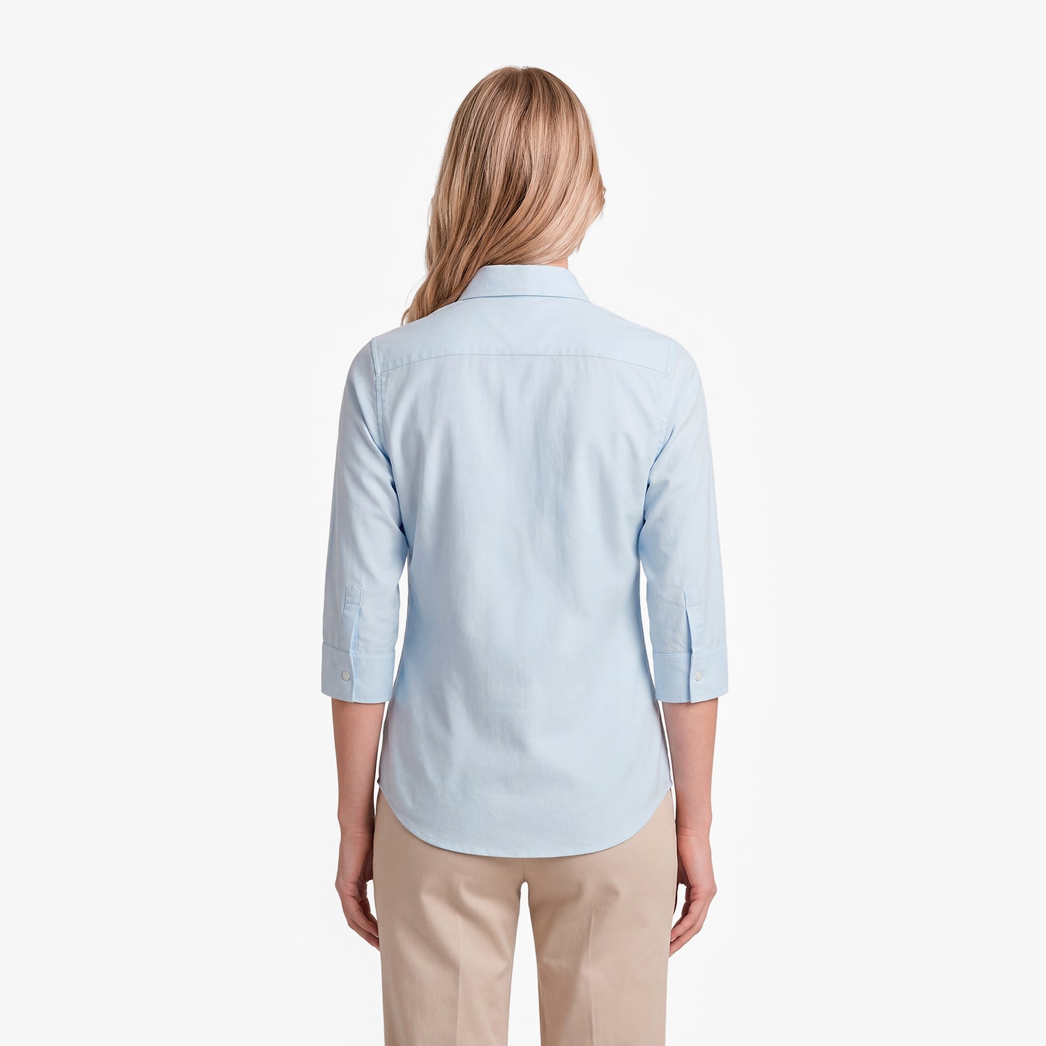 Woman wearing a light blue shirt and beige pants on a white background