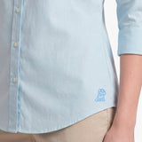 Light blue shirt with a small logo on a plain background