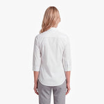 Woman wearing a white shirt and gray pants on a white background