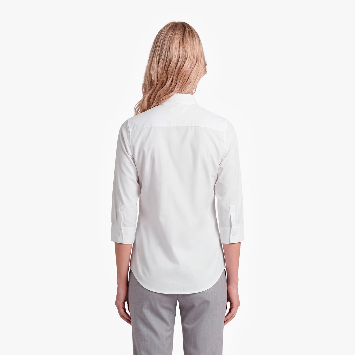 Woman wearing a white shirt and gray pants on a white background