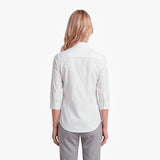 Woman wearing a white shirt and gray pants on a white background